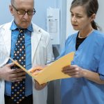 Doctor and nurse examining patient records in a clinical setting