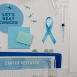 Flat lay showing cancer awareness items with blue ribbon and research tools
