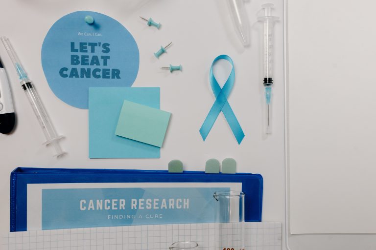 Home 36 Flat lay showing cancer awareness items with blue ribbon and research tools