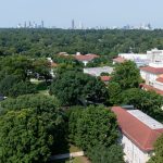 Emory campus buildings amid trees with Atlanta skyline in the distance