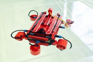 Stock photo of a red robotic prototype with wheels and wires